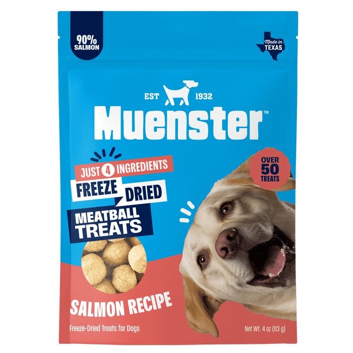 Bright blue Muenster dog-treat package featuring a happy tan dog, salmon meatball treats, and labels for 90% salmon, freeze-dried, 4 ingredients.