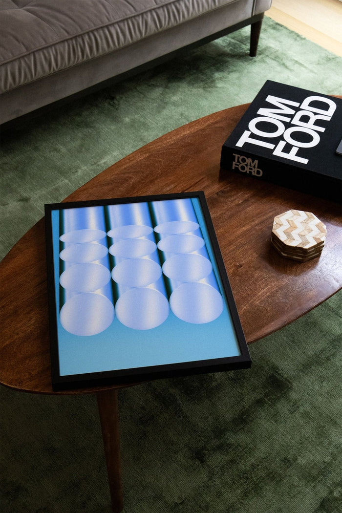 Tubes - Fergus Hannant artwork with geometric blue and white circles on a wooden table next to a Tom Ford book