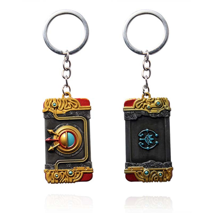 Zelda Purah Pad Keychain, Adventure Symbol: gold, black ornate book-themed design, fantasy, ornate style