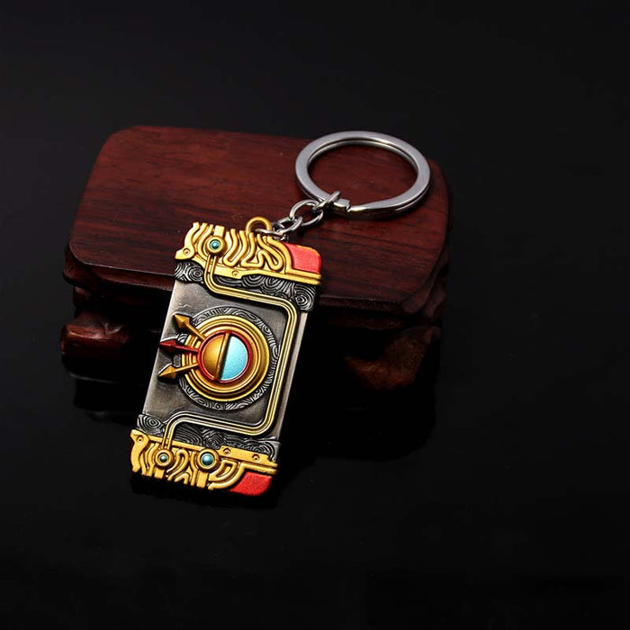 Zelda Purah Pad Keychain, Adventure Symbol: gold, black ornate book-themed design, fantasy, ornate style