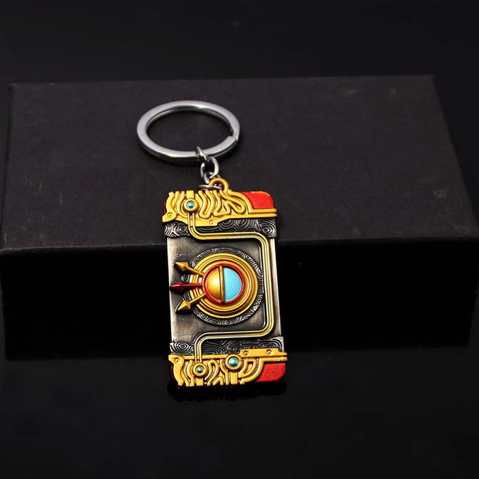 Zelda Purah Pad Keychain, Adventure Symbol: gold, black ornate book-themed design, fantasy, ornate style