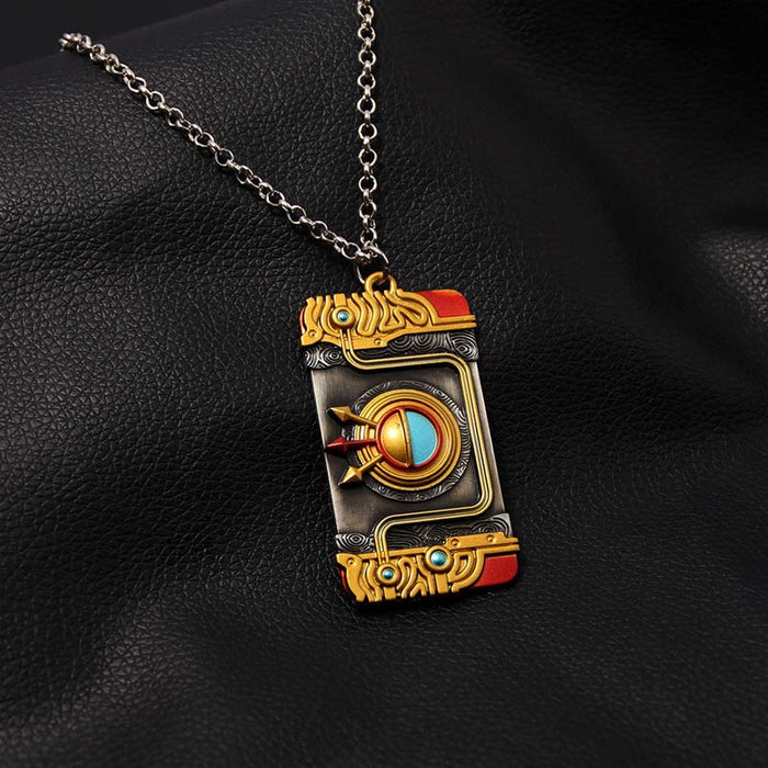 Zelda Purah Pad Keychain, Adventure Symbol: gold, black ornate book-themed design, fantasy, ornate style